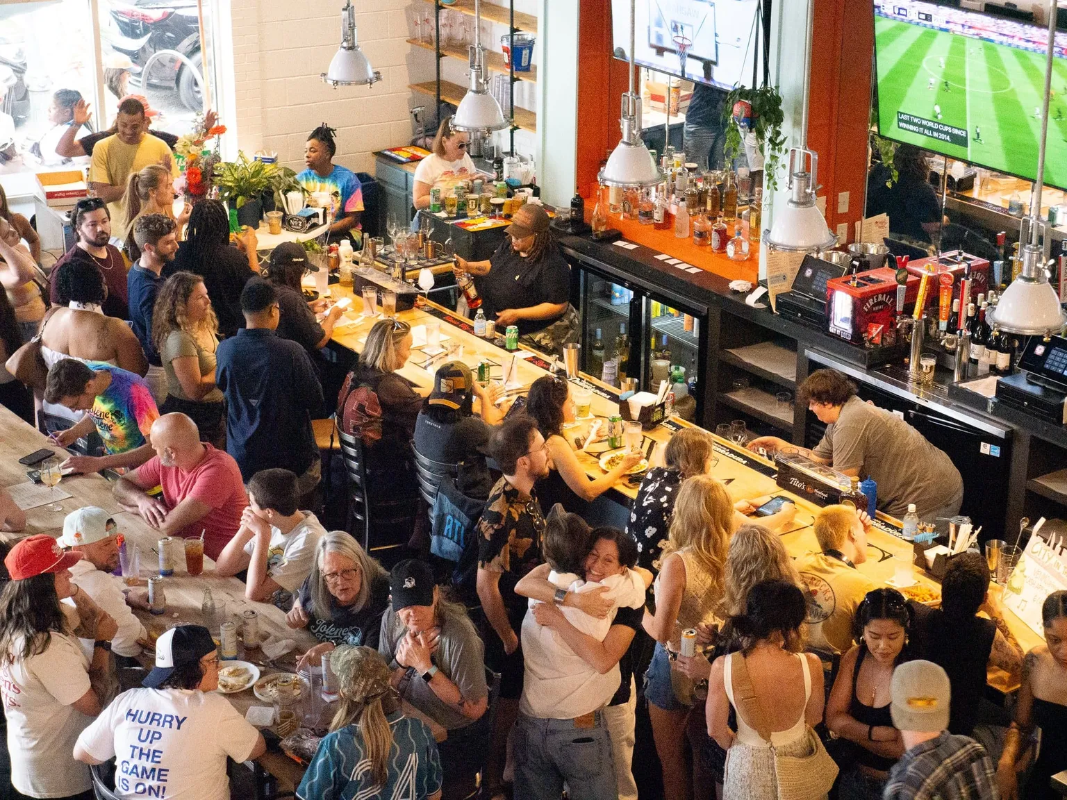 A crowd of fans shoulder to shoulder along the bar at Jolene Jolene during a watch party