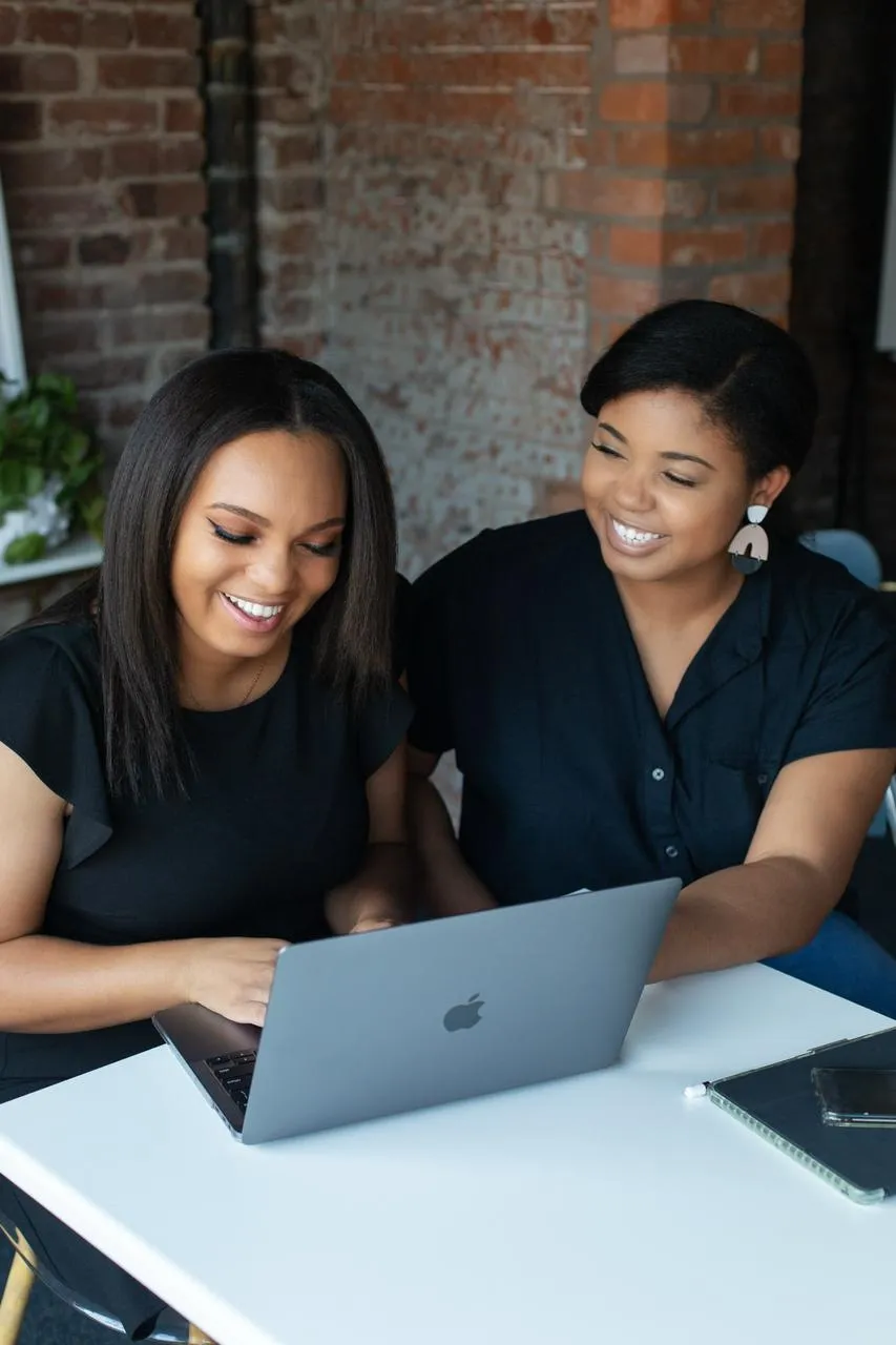 LRC Social founder Lisa Camp and marketing coordinator Jasmine reviewing content together on a laptop