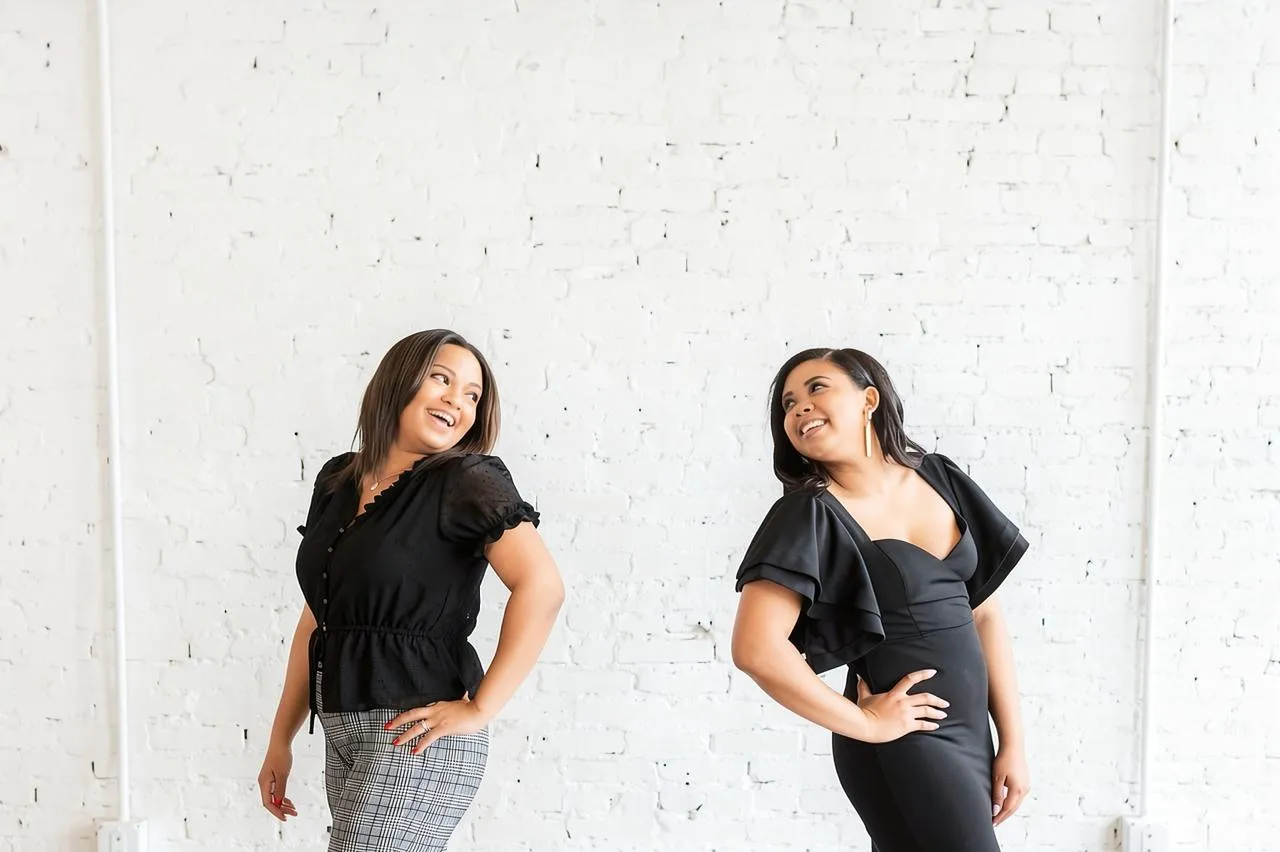 Two LRC Social team members smiling at each other in a bright studio