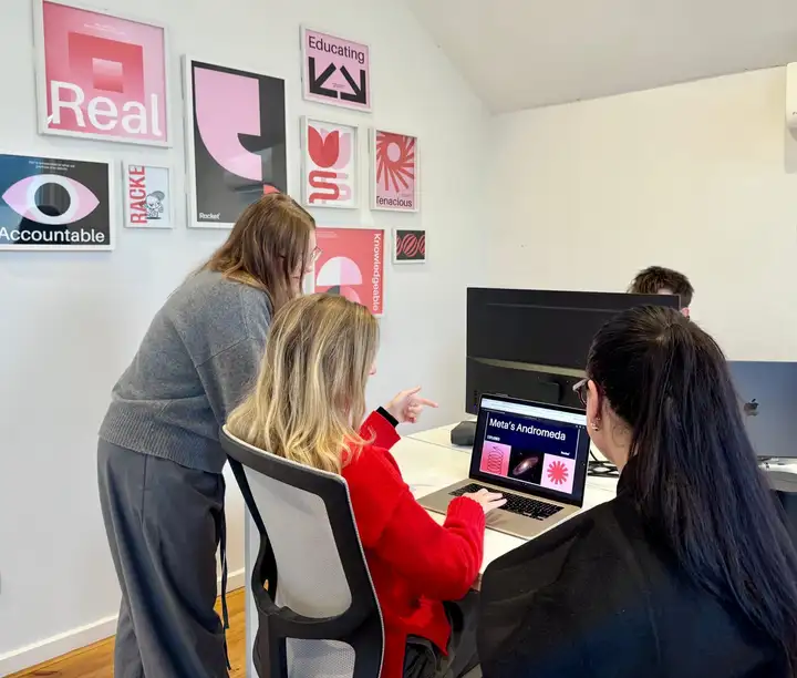 Racket Agency team members reviewing work on a laptop in their Melbourne office