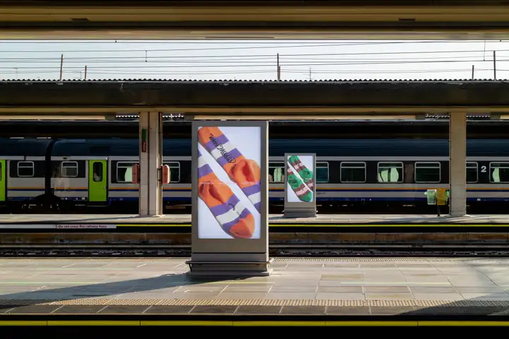 SOCKSSS campaign displayed on advertising panels at a railway station