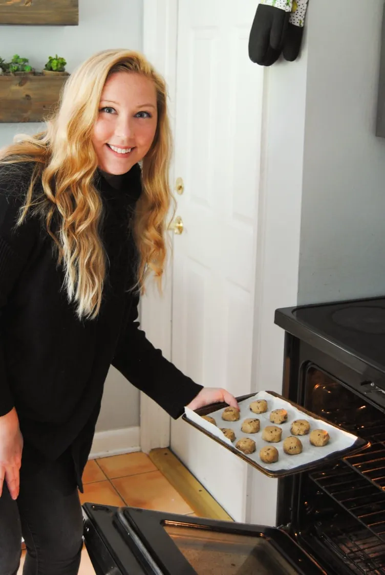 Marley Goldin putting a tray of cookie dough in the oven