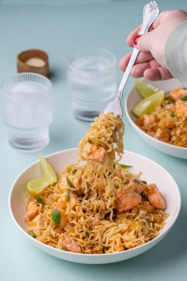Fork lifting noodles from a bowl of salmon ramen from Marley's Menu