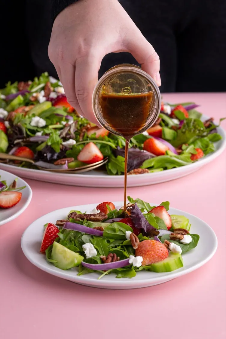 Balsamic dressing poured over a strawberry salad from Marley's Menu