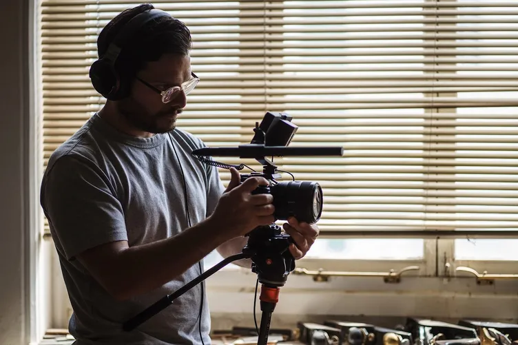 Filming with a camera, monitor and shotgun microphone in a workshop