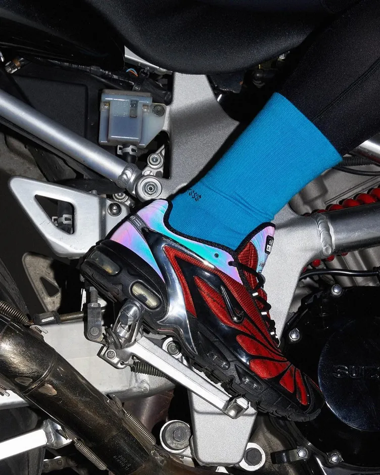 Blue SOCKSSS sock and sneaker resting on a motorcycle from the Mega Blue campaign