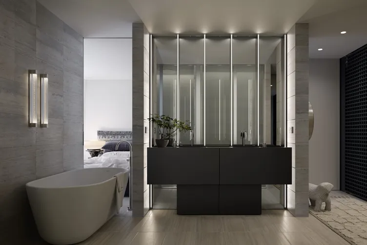 A travertine bathroom by Studio Terrando with a freestanding bath and mirrored vanity lit by vertical strip lights