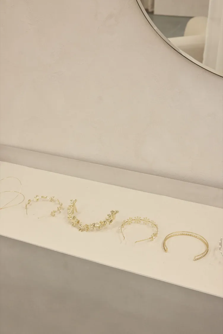 Gold bridal headpieces laid out beneath a round mirror at The Fall Bride