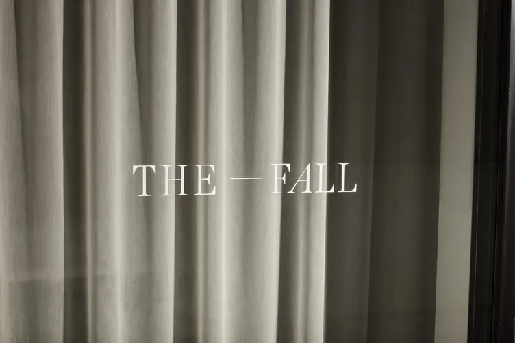 The Fall's logotype on the store window, against a linen curtain